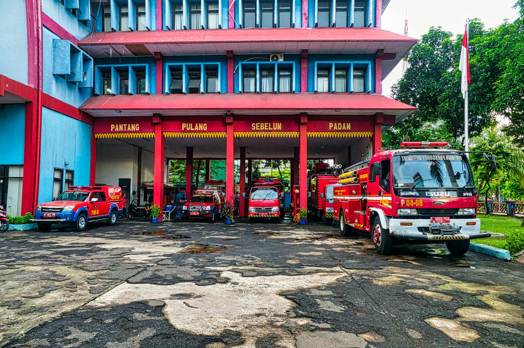 Fire trucks parked outside a vibrant fire station in Jakarta, Indonesia.